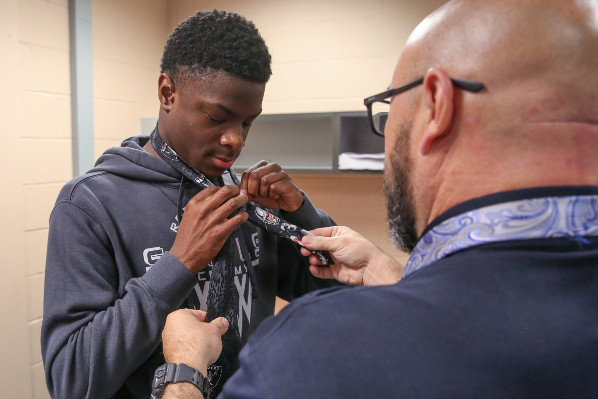 helping student tie a tie