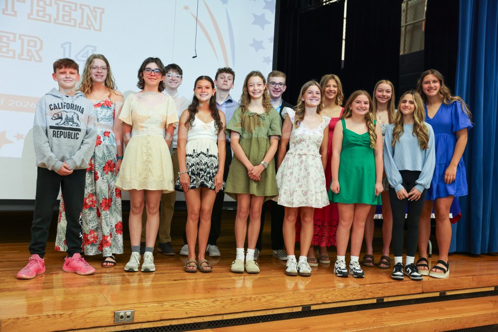 Group of students posing together on stage for a school event.