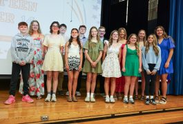 Group of students posing together on stage for a school event.