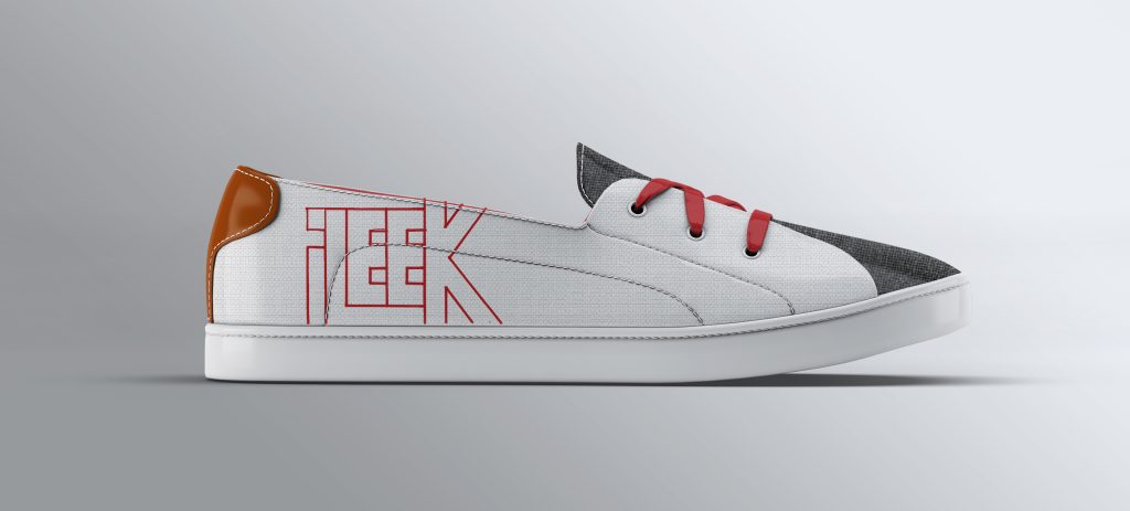 Black and white sneaker with red accents on a gray surface.